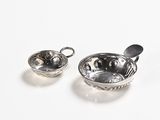 two bowls and spoons sitting on a white surface