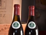 two bottles of wine sitting next to each other on a table