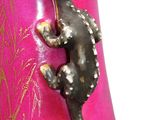 a pink vase with a small lizard on it