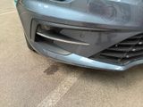 a car that has been dented and is parked in a parking lot