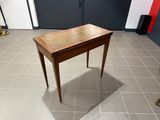 une petite table en bois avec un plateau en verre, posée sur un sol carrelé