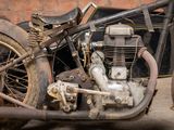 an old motorcycle parked in front of a brick wall