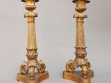 deux bougeoirs en or posés sur une table