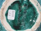 a green vase that has a tag on it