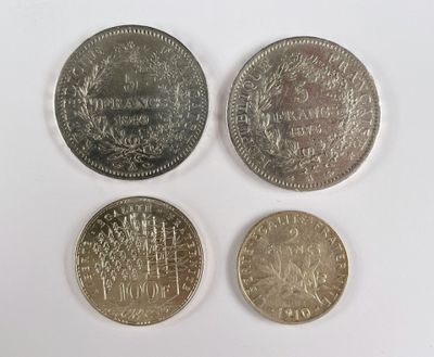 quatre types de pièces différents posés sur une surface blanche