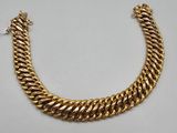 a gold chain bracelet with a clasp on a white background