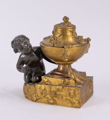 an antique bronze figurine of a boy with a bowl of fruit