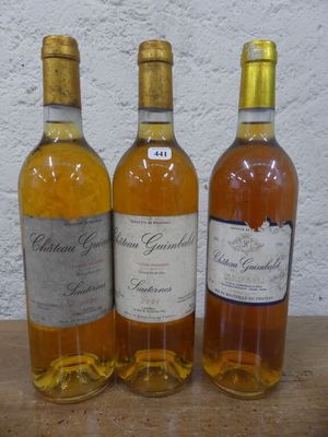 trois bouteilles de vin posées sur une table, l'une à côté de l'autre