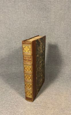 an old book sitting on top of a table next to a gray wall