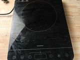 une plaque de cuisson noire surmontée d'un brûleur noir