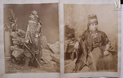 an old photo of two men in traditional clothing sitting on a chair