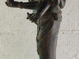 bronze statue of a woman holding a bird and a bird in her hand