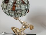 a statue of a man holding a glass ball on his head