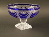 un saladier en verre bleu posé sur une table