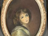 painting of a young girl in a gold frame with a black background