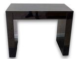 La console noire est dotée d'un plateau en verre et d'un piètement en métal.