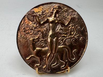une image représentant une assiette en or sur laquelle figurent une femme et un chien