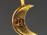 an image of a gold crescent pendant with a eye on it