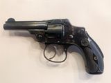 an old revolver on a white surface with a black handle