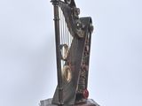 a metal harp sitting on a wooden stand on a white surface