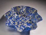 a blue and gold glass bowl with gold leaf designs
