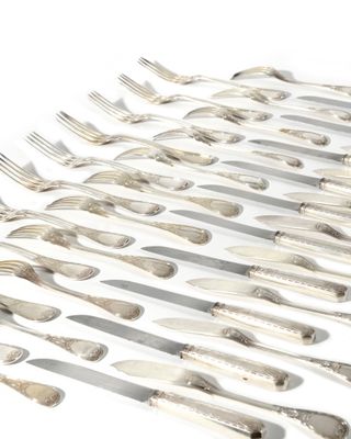 de nombreuses fourchettes et cuillères disposées sur une surface blanche