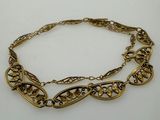 a close up of a gold chain bracelet on a white surface