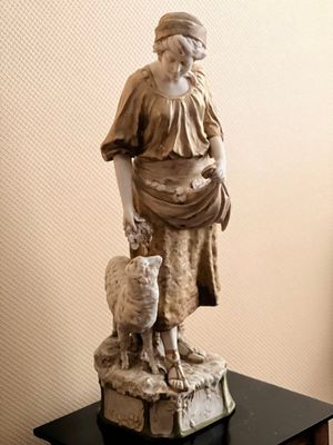 a statue of a woman with a sheep on a table