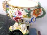 un vase orné de fleurs peintes, posé sur une table