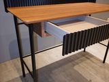 a desk with a drawer on it in the middle of a room