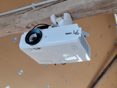 une photo d'un projecteur fixé à une poutre en bois