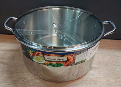 une grande casserole en métal avec un couvercle, posée sur une table en bois