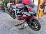 a red and white motorcycle parked in front of a building