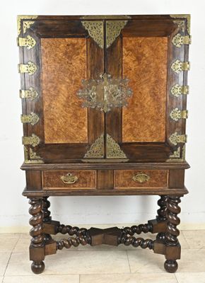 an old wooden cabinet with two doors and a drawer on top of it