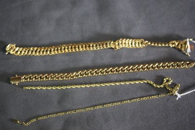 three different types of gold chains on a black background