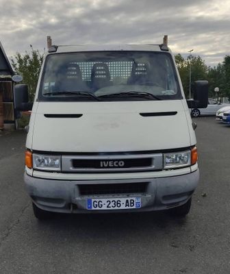 une camionnette blanche garée dans un parking avec d'autres voitures