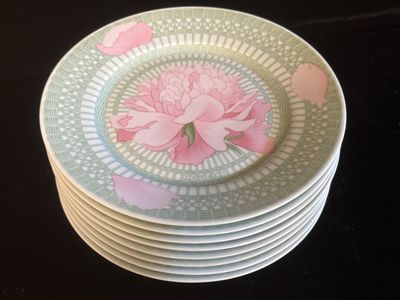 une pile d'assiettes ornées d'une fleur rose