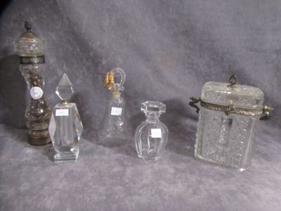 five glass bottles and a small glass jar on a table