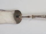 an old silver spoon with a handle and a handle on a white surface