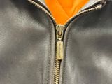 the zipper of a black leather jacket with an orange lining