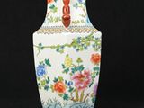 a white vase with flowers on it on a black background