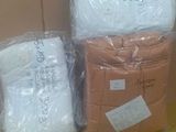 three boxes of white blankets sitting on top of a cardboard box