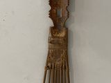 a wooden comb with a bird on it on a white surface