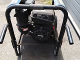 an image of a small engine on a cart in front of a garage