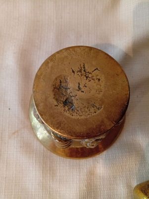 un petit objet métallique posé sur un tissu blanc