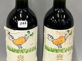 two bottles of red wine sitting next to each other on a table