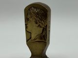 un gros plan d'une statue en bronze représentant une femme sur fond blanc