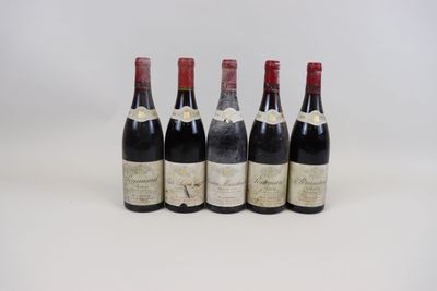 quatre bouteilles de vin sont alignées sur une surface blanche