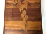 a picture of a wooden cutting board with leaves on it