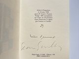 an open book with a handwritten poem on it sitting on a table